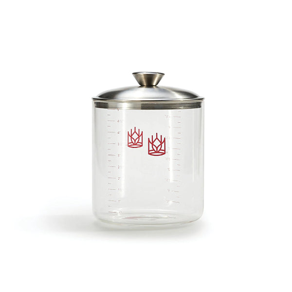 Clear glass sourdough crock with silver lid on a white background